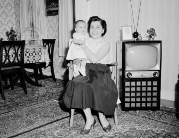 grayscale photo of girl in dress standing on carpet