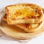 french toast with honey syrup on wooden plate