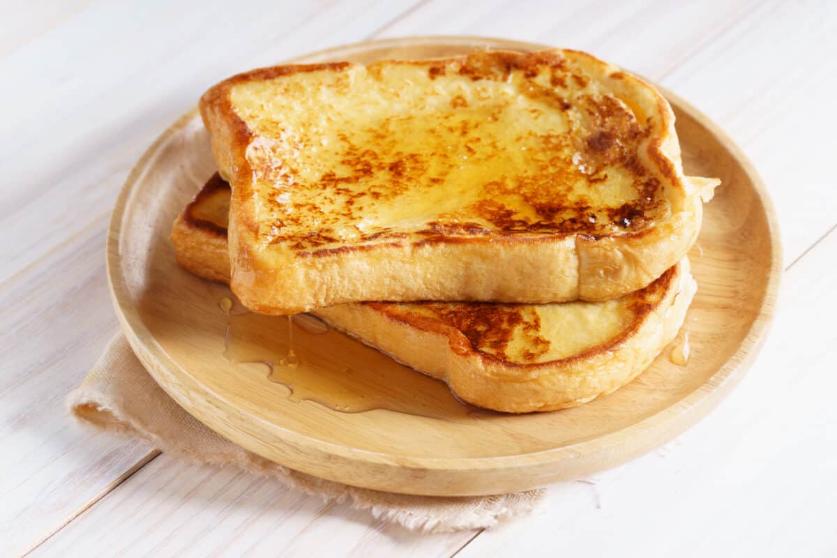 french toast with honey syrup on a wooden plate