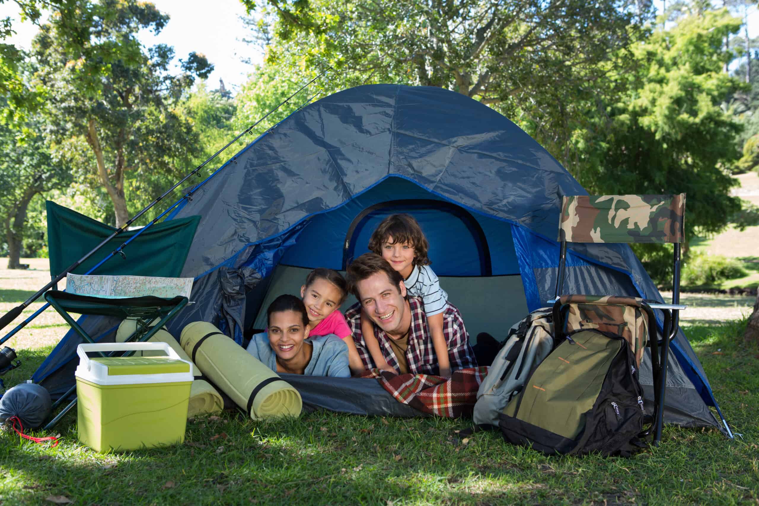 Happy family on a camping trip in their tent on a sunny day