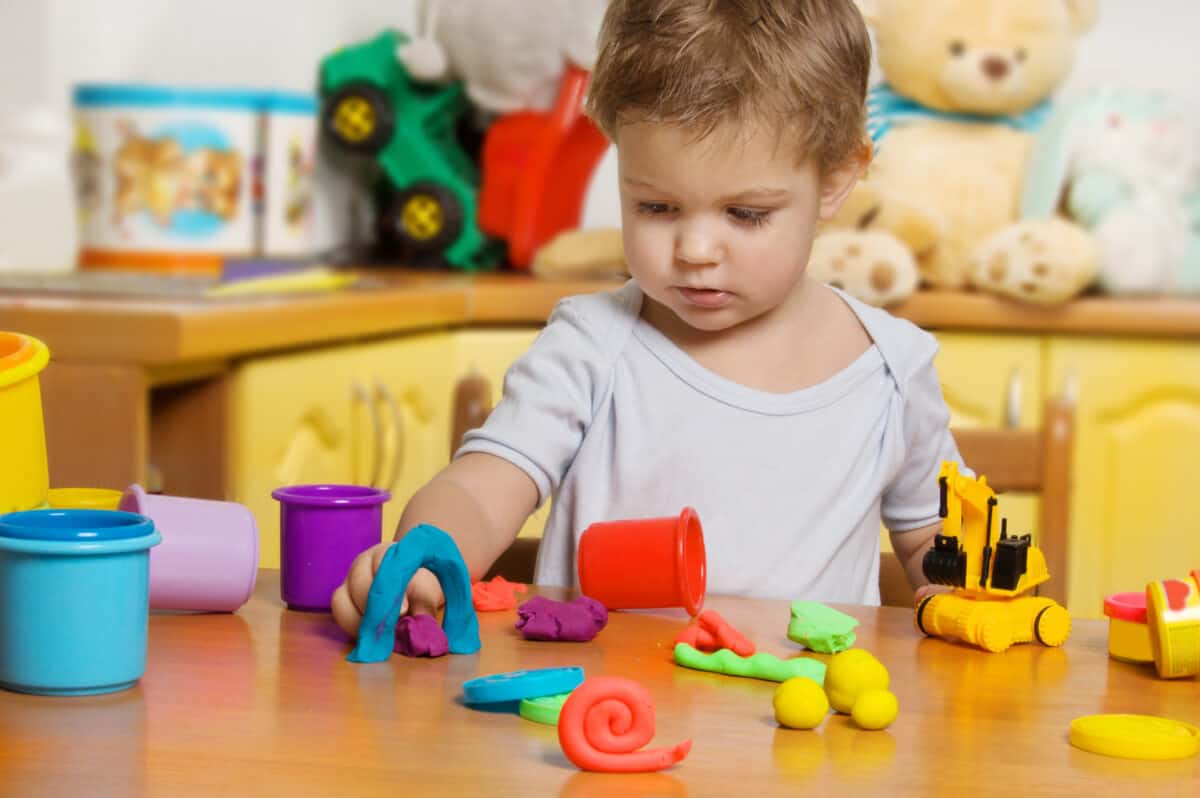 2 years old child playing plasticine in children's room