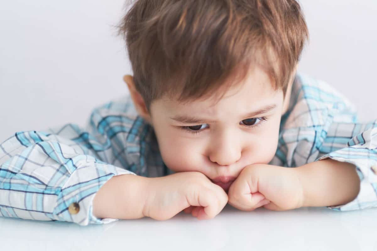 portrait of a cute little boy naughty face. stubborn kid 3 years old does not listen to mom