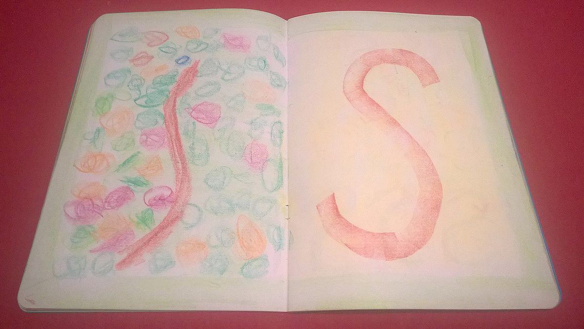 pages from a first grade Waldorf school morning lesson book. The left pages is a drawing of a red  snake in grass. The right page is a drawing od the letter S. All of the drawing is with crayons. 