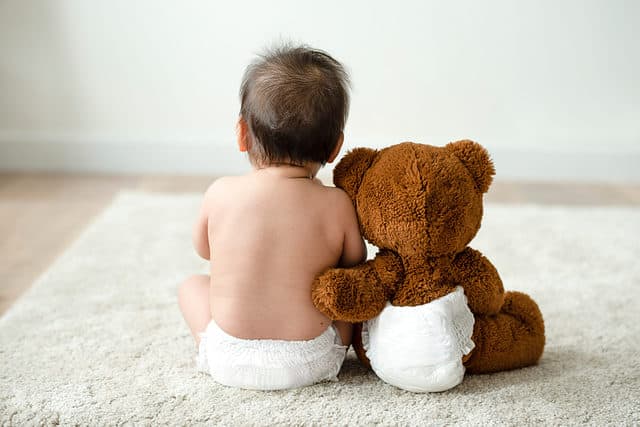 Baby and teddy bear in diaper