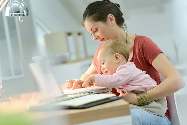 Mom typing with baby in lap