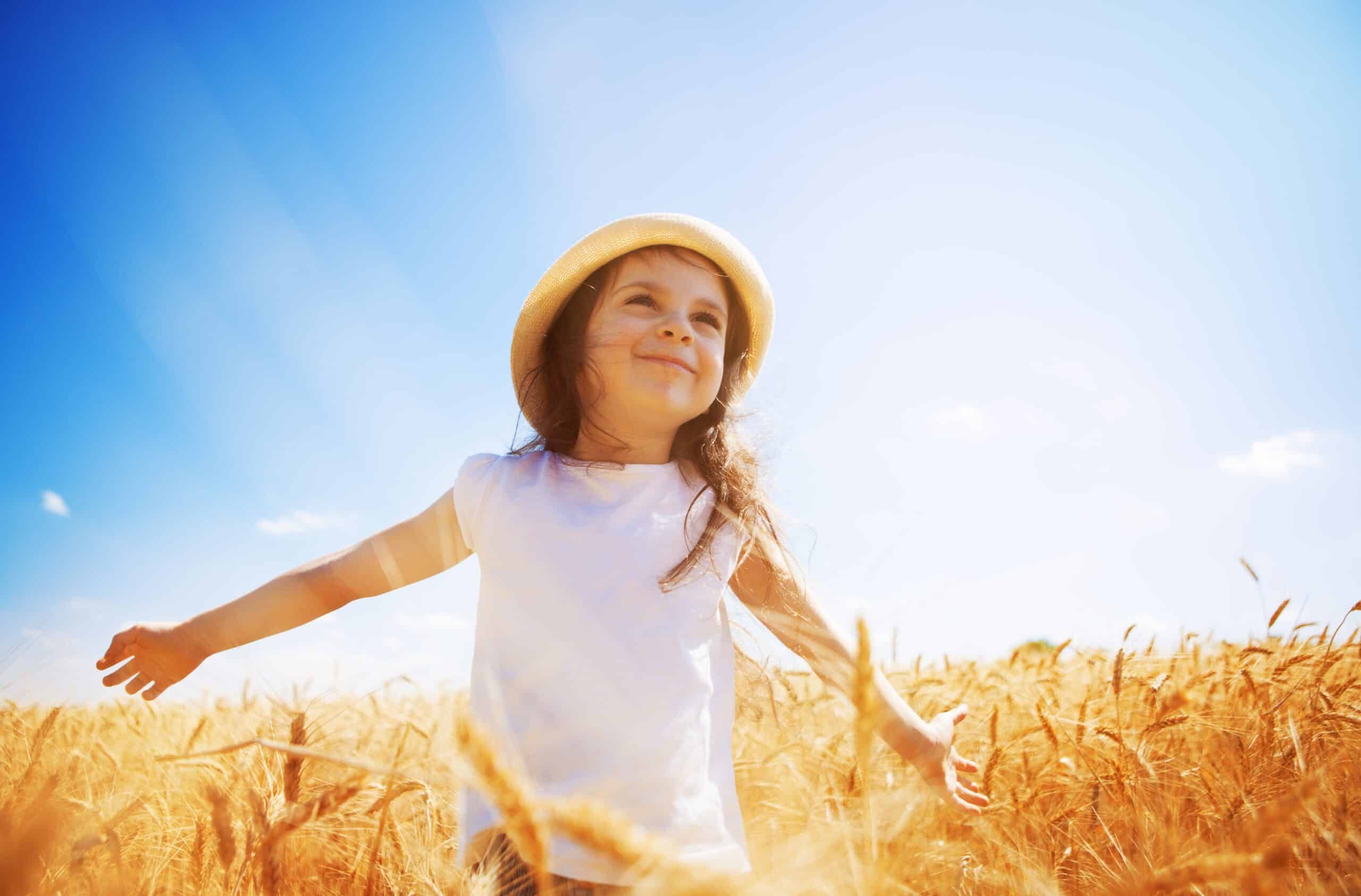 happy girl walking and enjoying life in the golden field. Nature beauty, sunny blue sky.