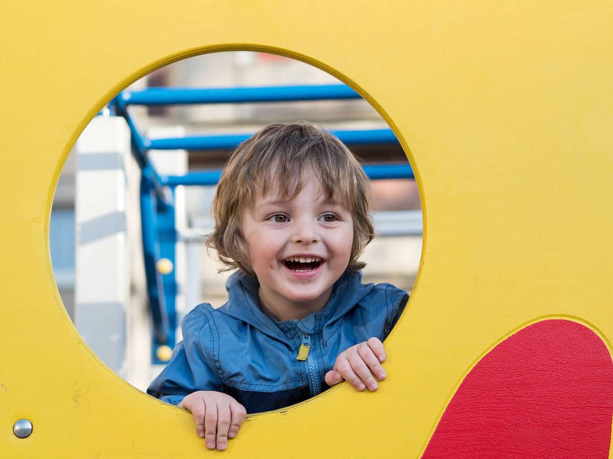 Funny cute happy baby playing on the playground. The emotion of happiness, fun, and joy. Smile of a child.