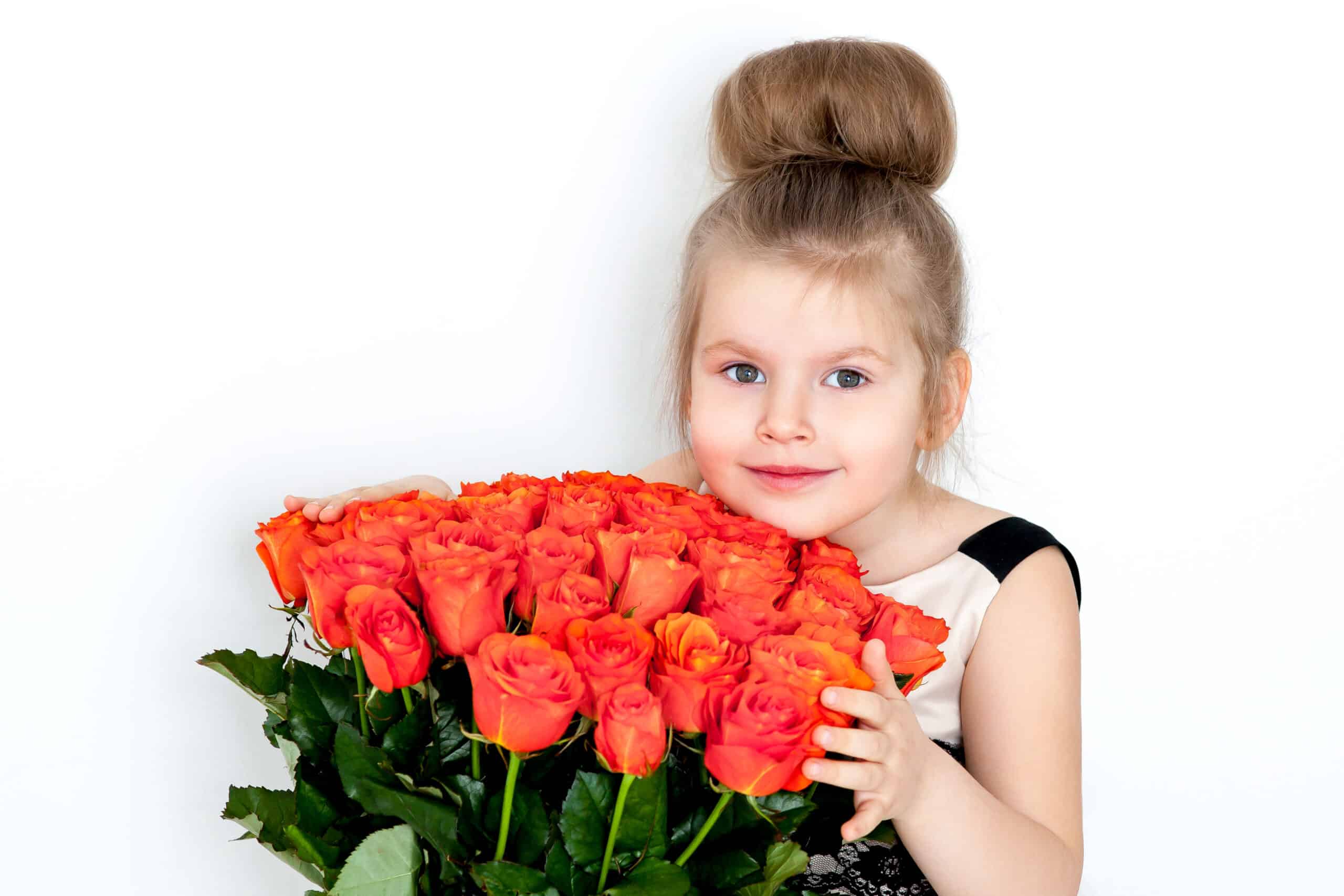 The little girl in an elegant dress with a bouquet of 51 orange roses