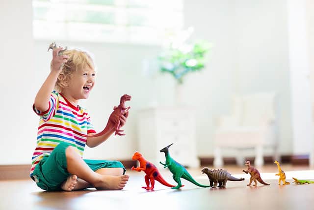 child playing with dinosaurs