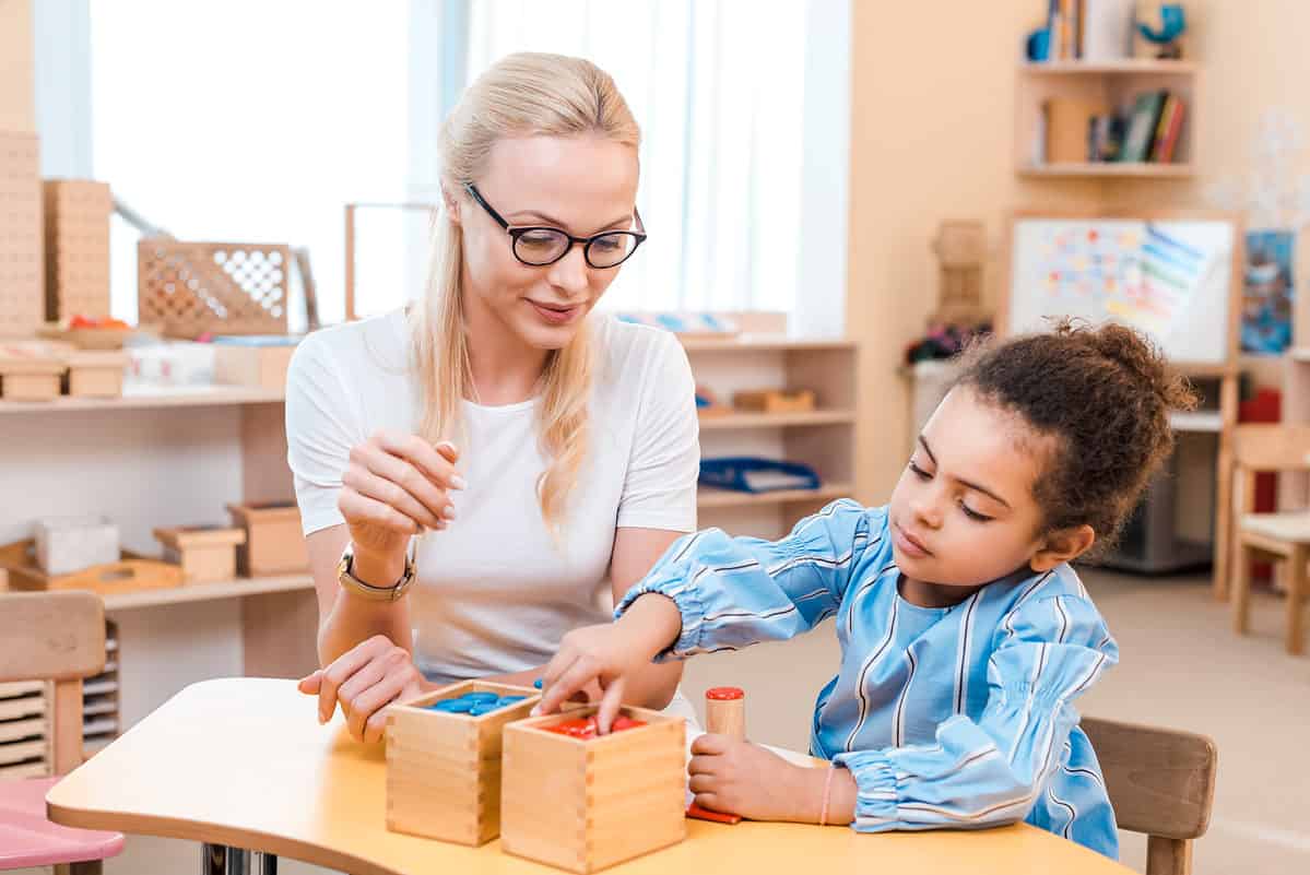 Teacher and student playing with a wooden game - schools in Florida