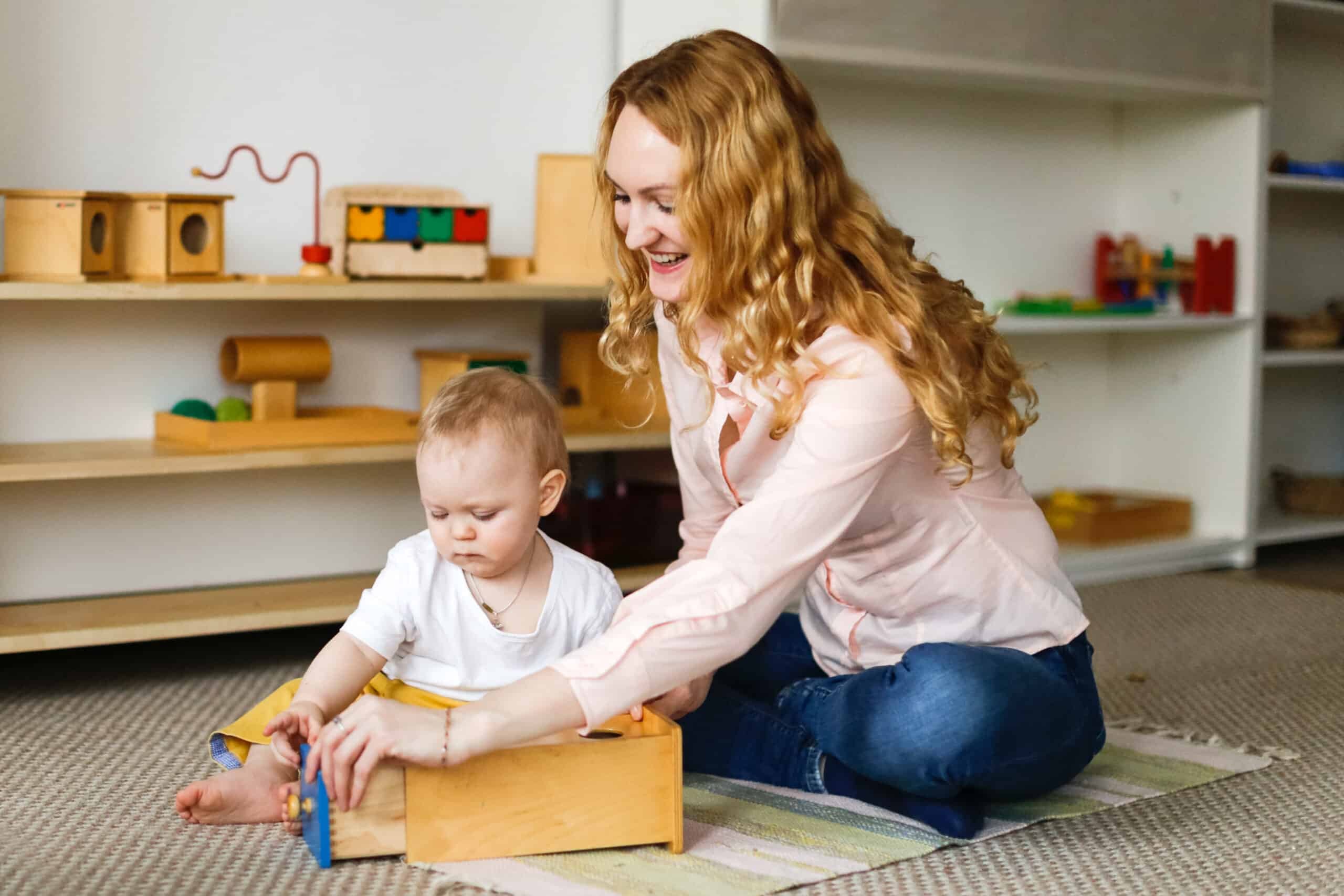 Teacher and baby play with Montessori materials