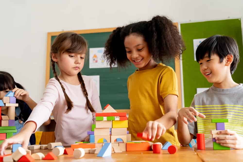 Elementary school students playing with building blocks.