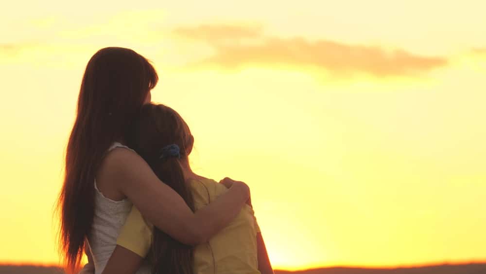 Mother and daughter watching sunset