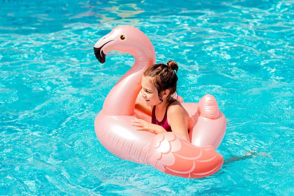 Little girl having fun in swimming pool. Summer outdoor activity during family vacation.