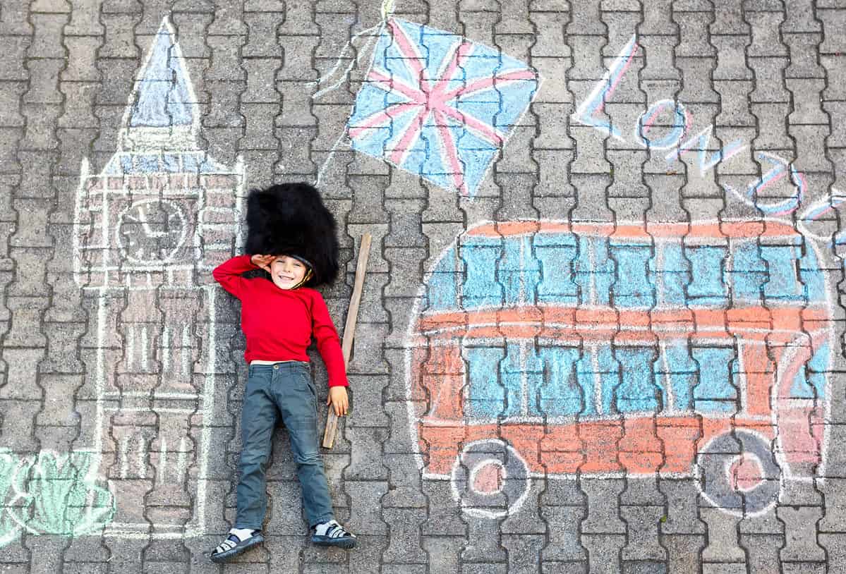 Boy laying on ground with London drawing around him