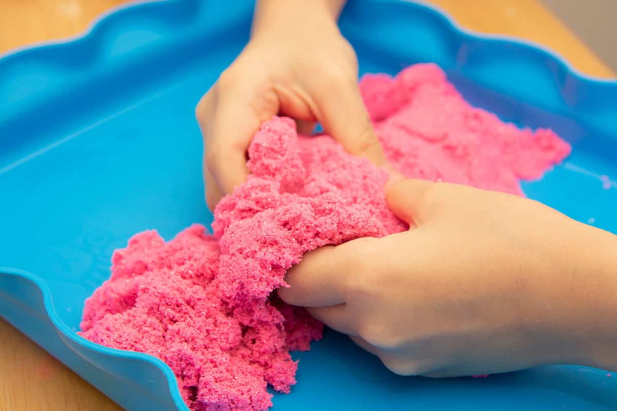 Child playing with Kinetic Sand 