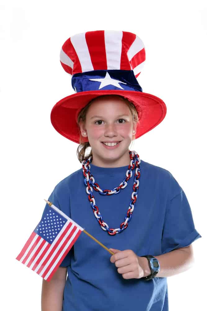 Happy girl holding American flag while smiling