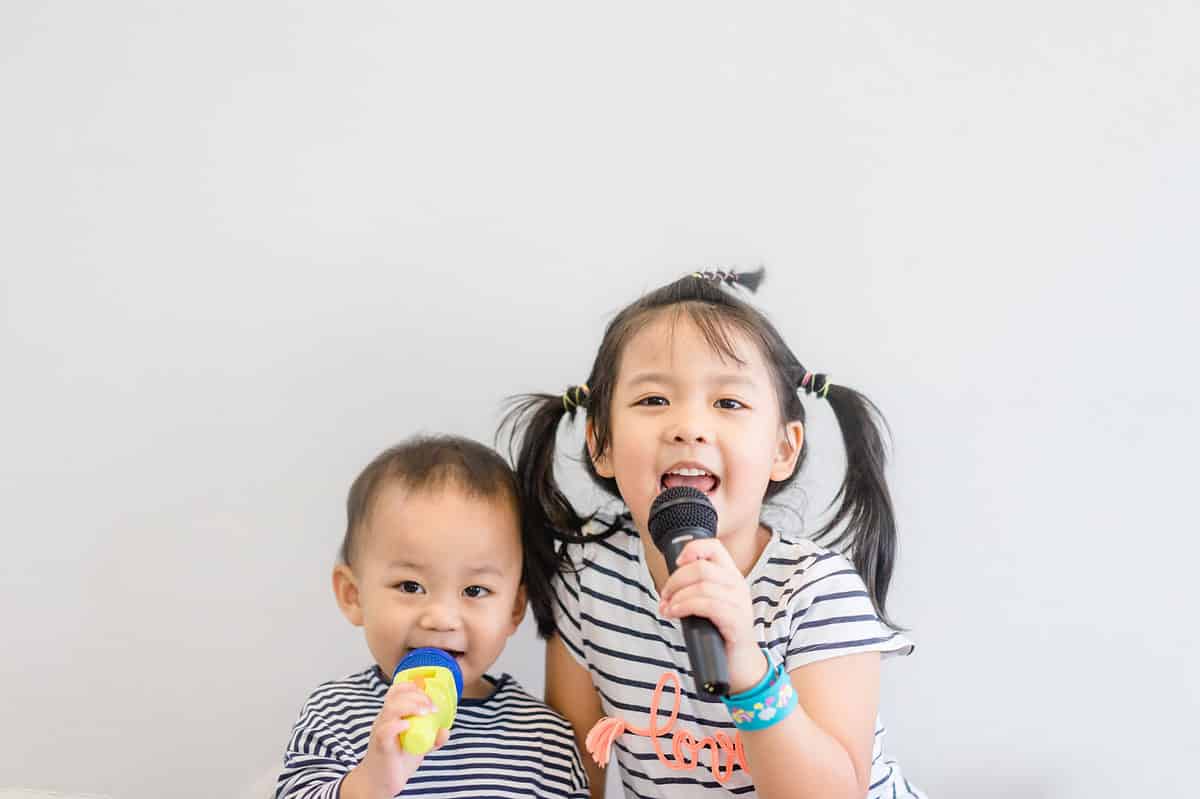 Two kids singing into microphones together