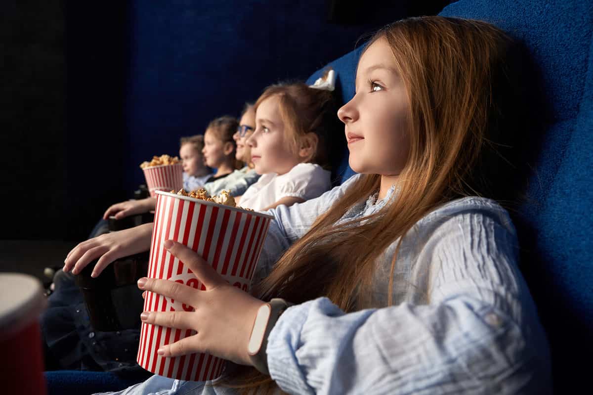 Children in movie theater eating popcornMovie trivia is a fun way to learn little-known facts about your child's favorite films. 