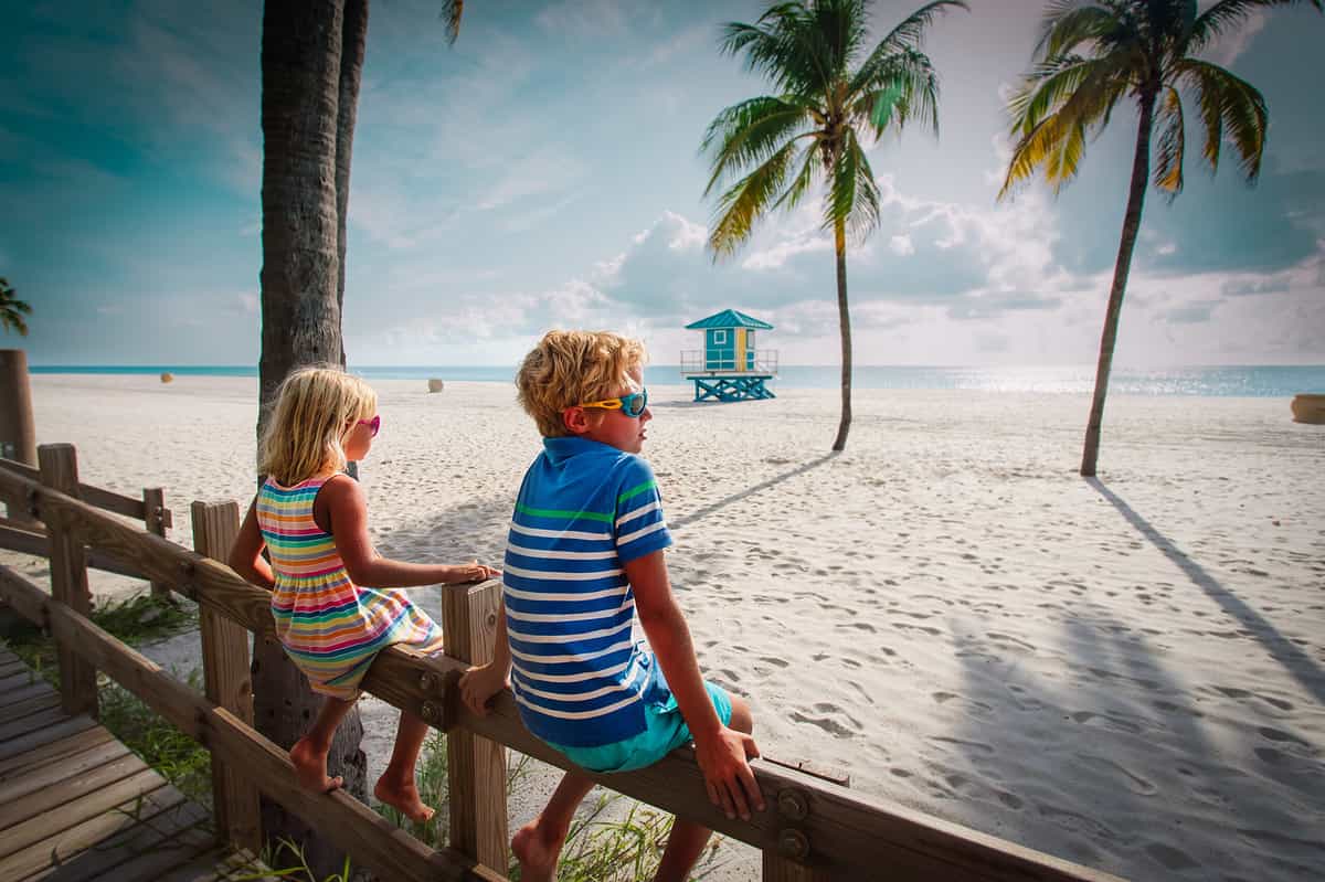 boy and girl at a beach looking at ocean