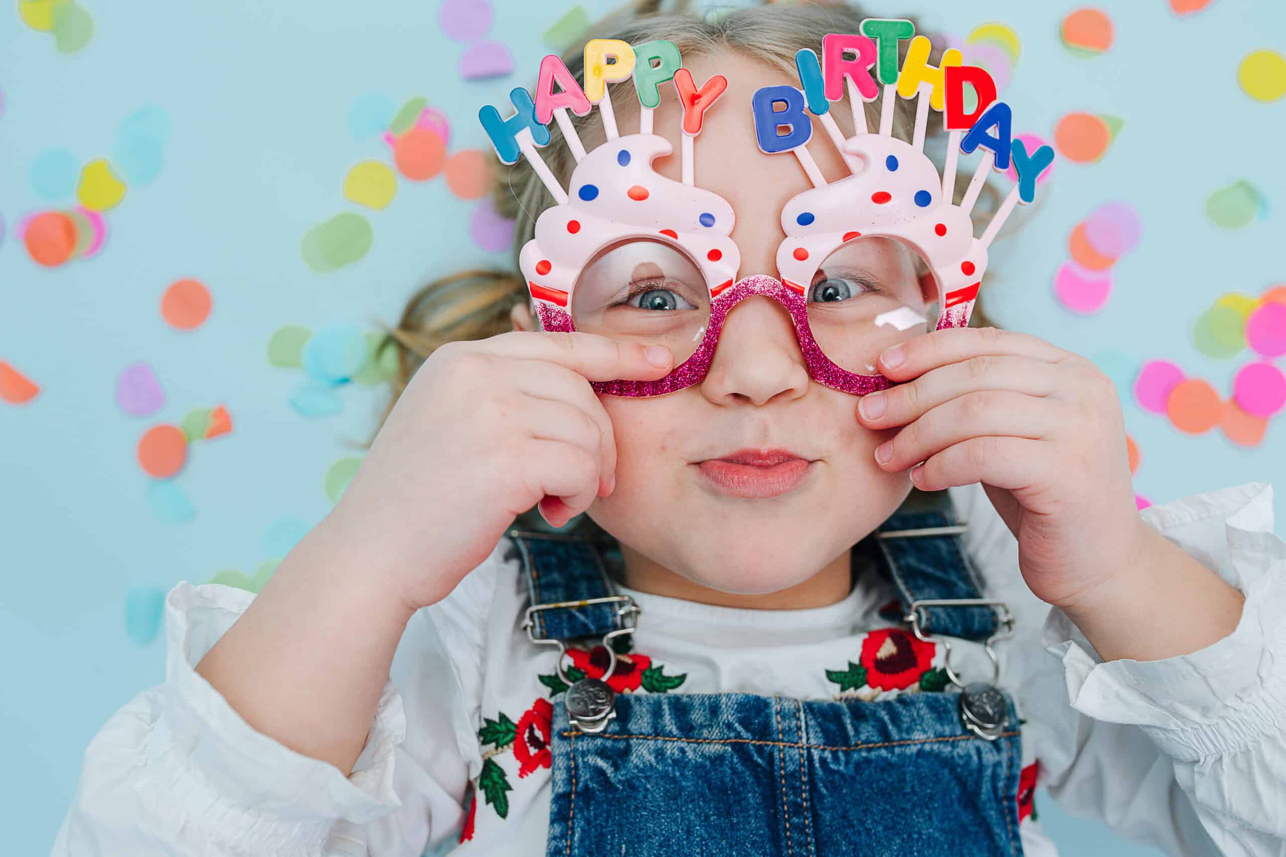 little girl with happy birthday glasses