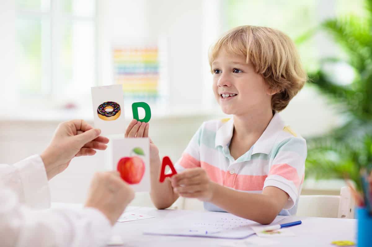 Happy student learning alphabet with cards