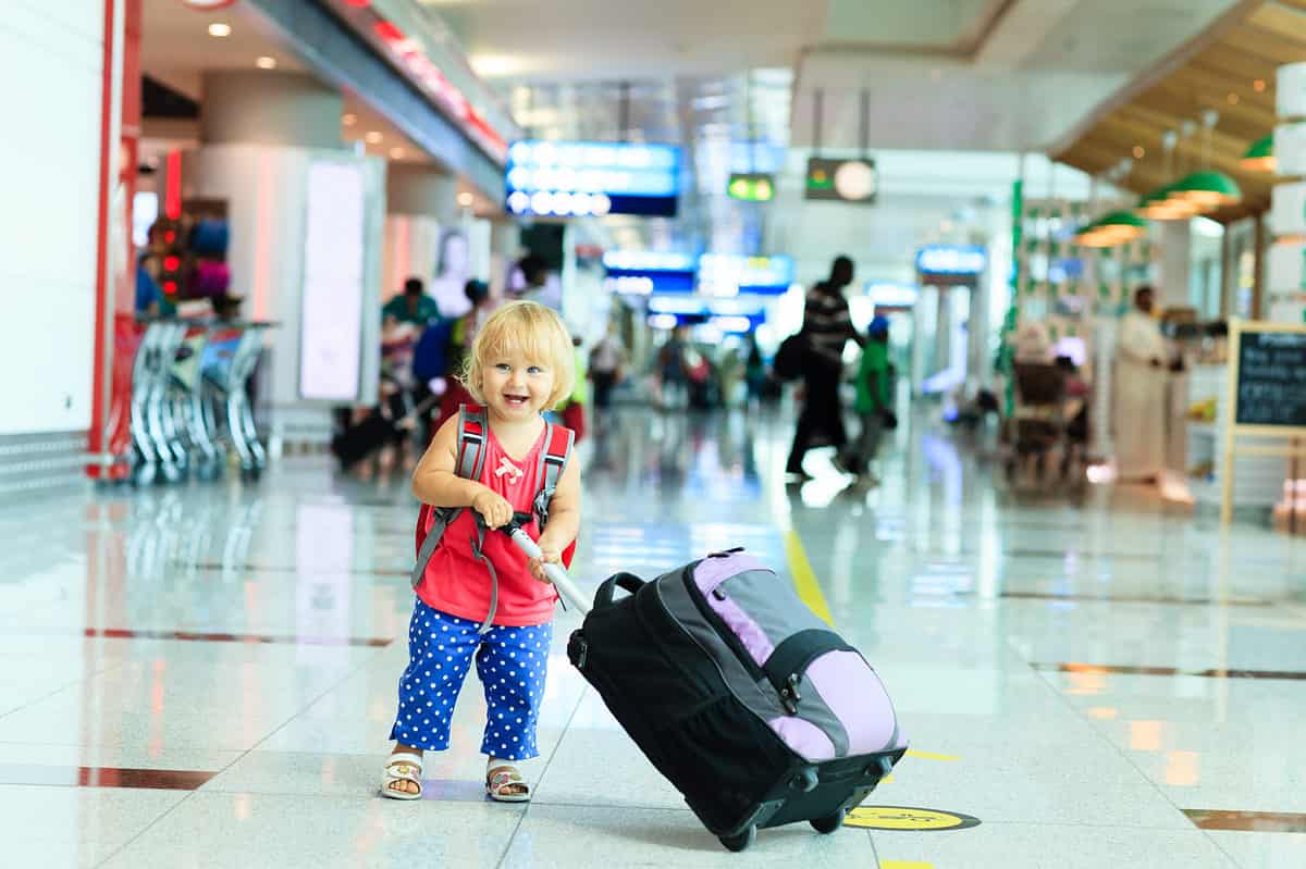Little girl with luggage in airport