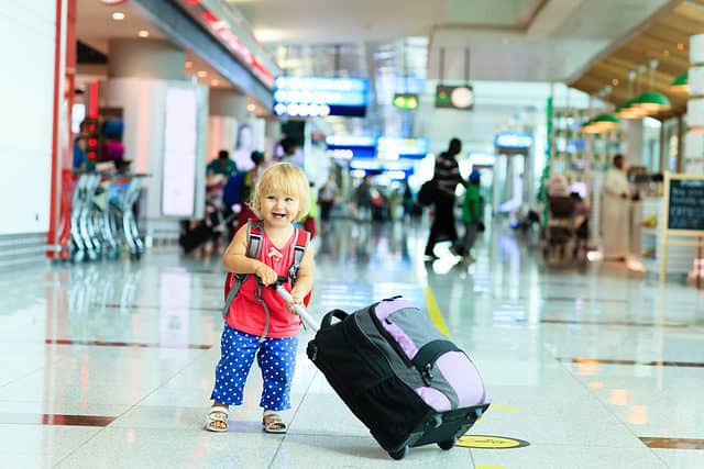 Little girl with luggage in airport