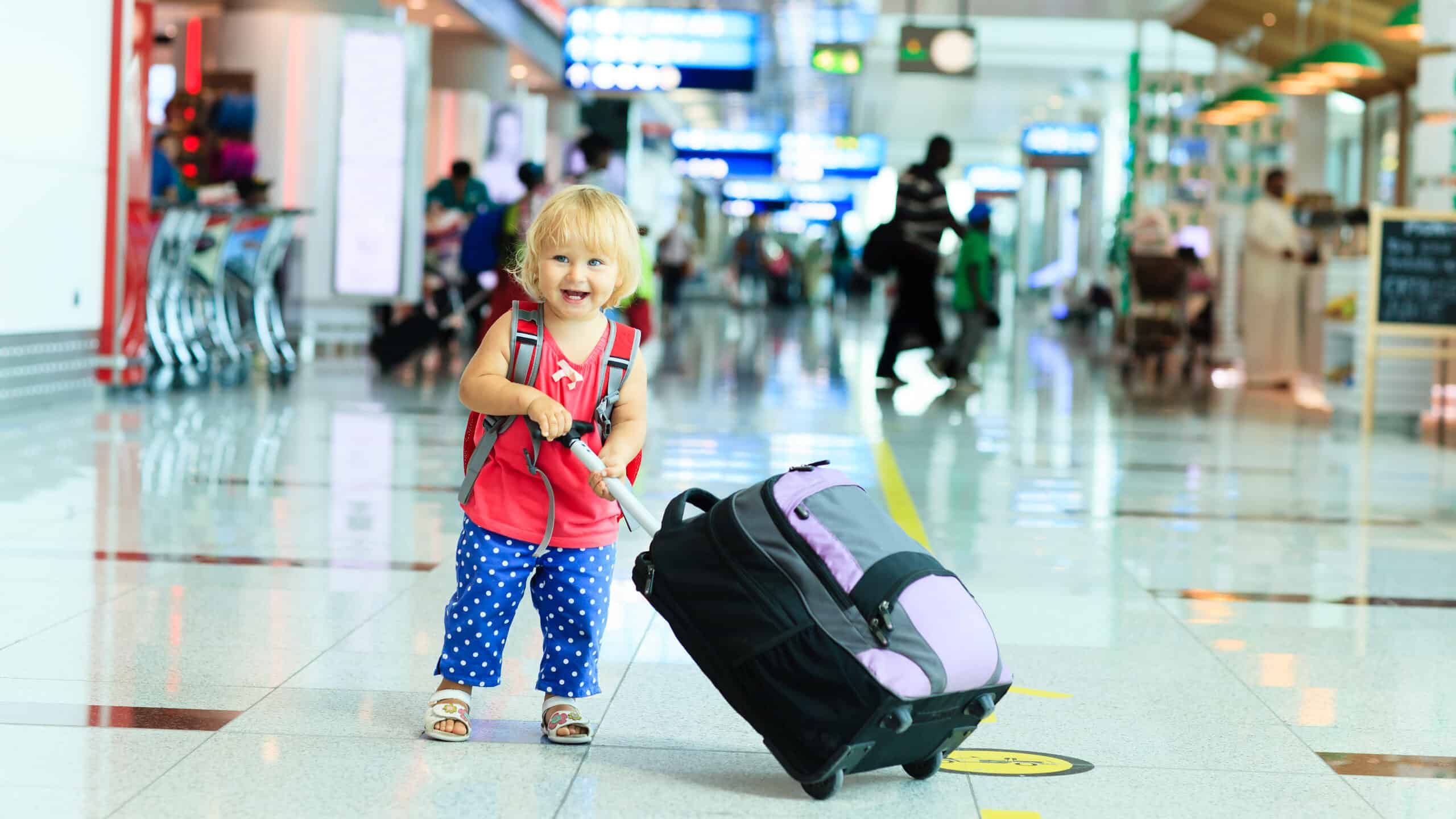 Little girl with luggage in airport