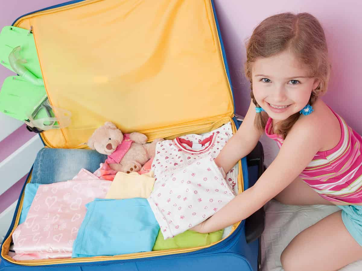 Little girl packing her clothes