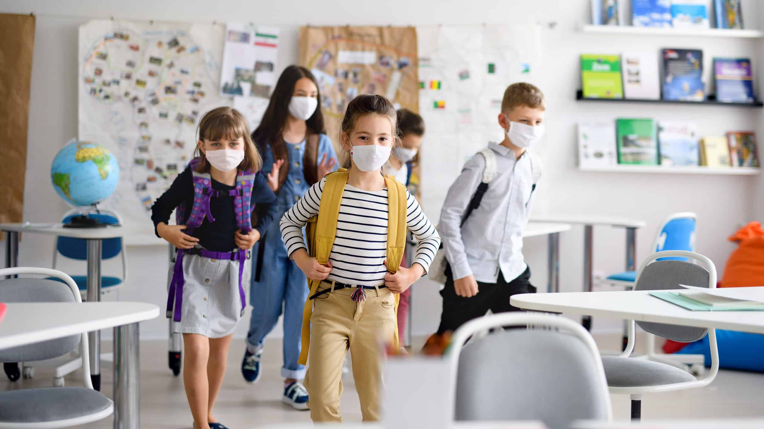 Group of children with face mask back at school after covid-19 quarantine and lockdown.