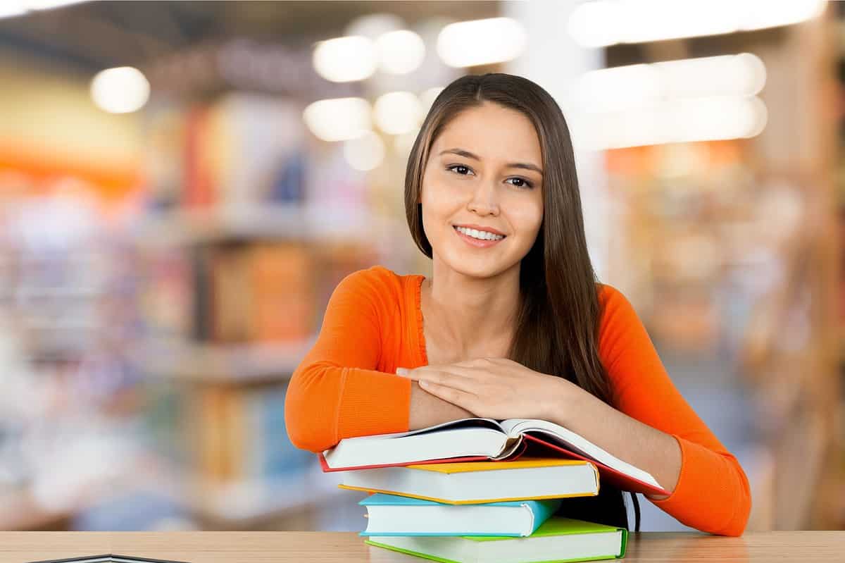 A high school student in orange looking at the camera.