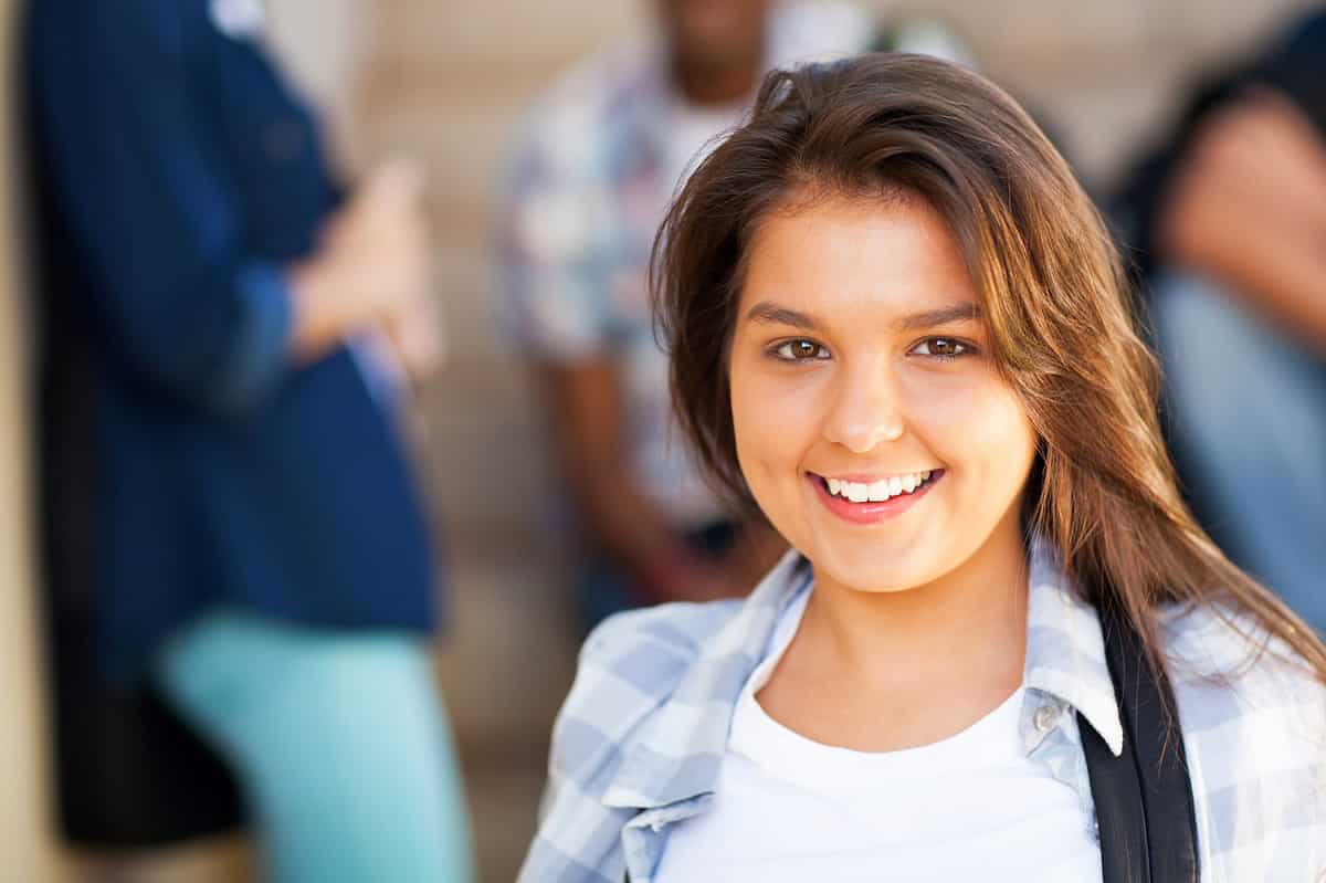 A student looking and smiling straight at the camera.