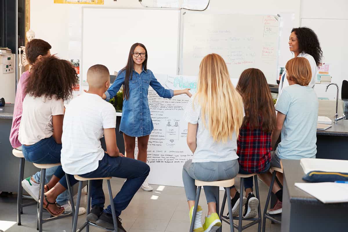 A middle school student discussing her presentation in front of class.