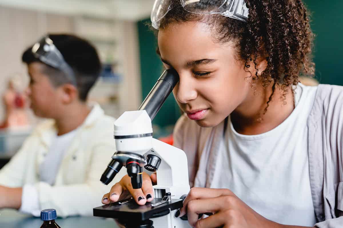 A photo of a student looking through a microscope.