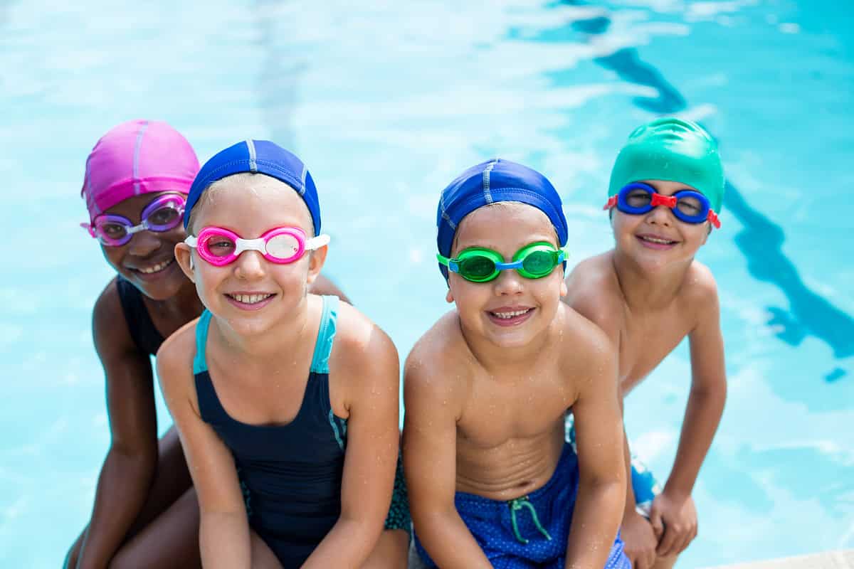 Portrait of little swimmers sitting at poolside