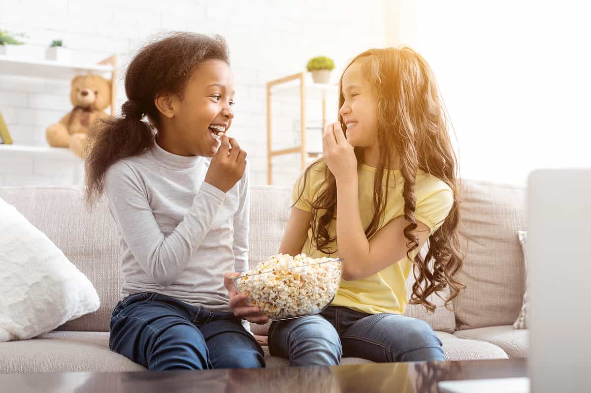 Best,Friends,Watching,Funny,Cartoon,And,Eating,Popcorn,,Sitting,On