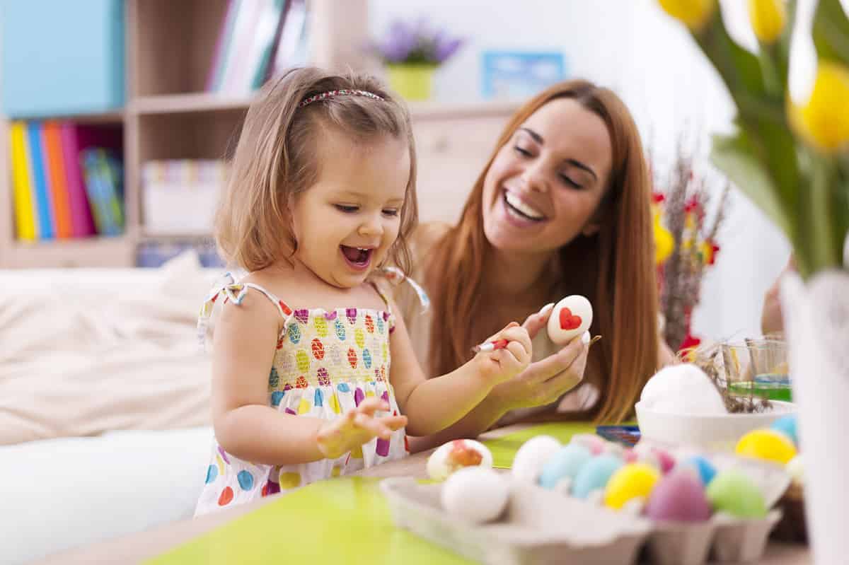 Mom and daughter painting Easter eggs 