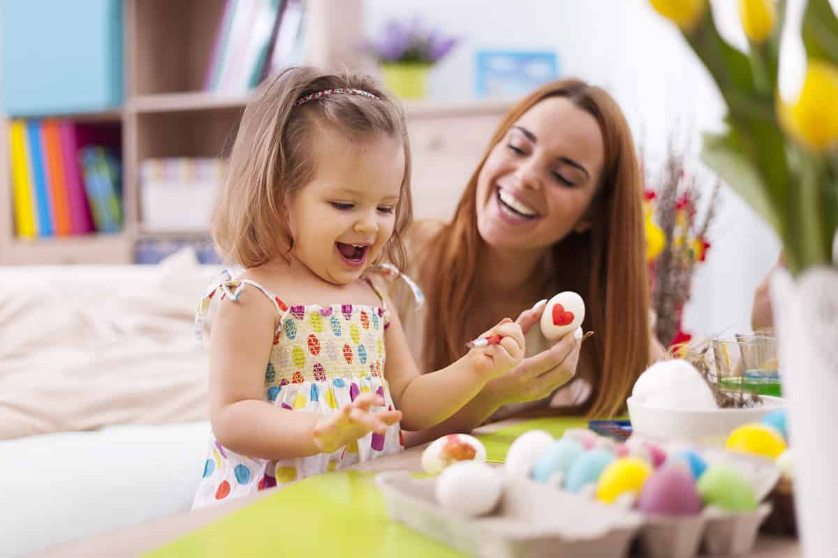 Mom and daughter painting Easter eggs
