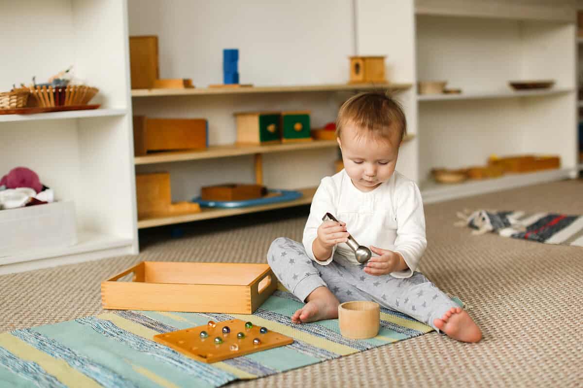 child playing next to a Montessori bookshelf