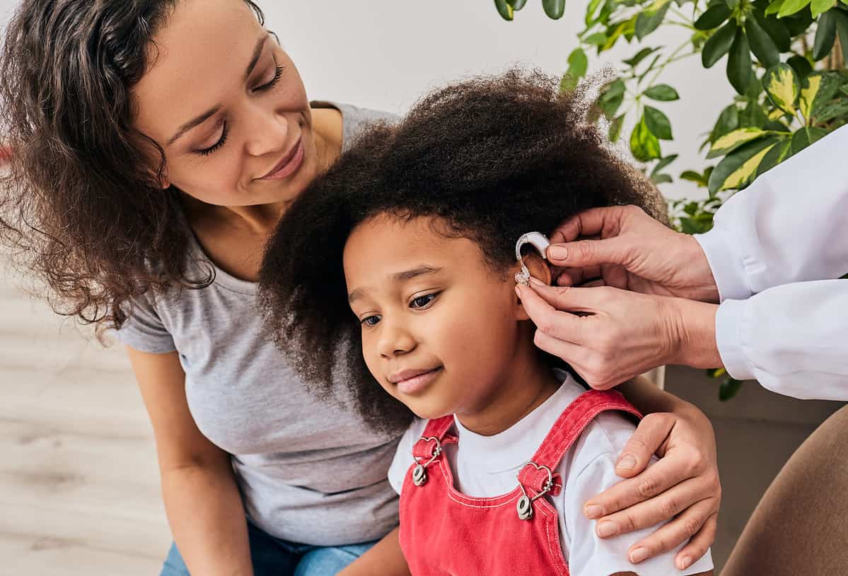 Young girl receiving hearing treatment with mother