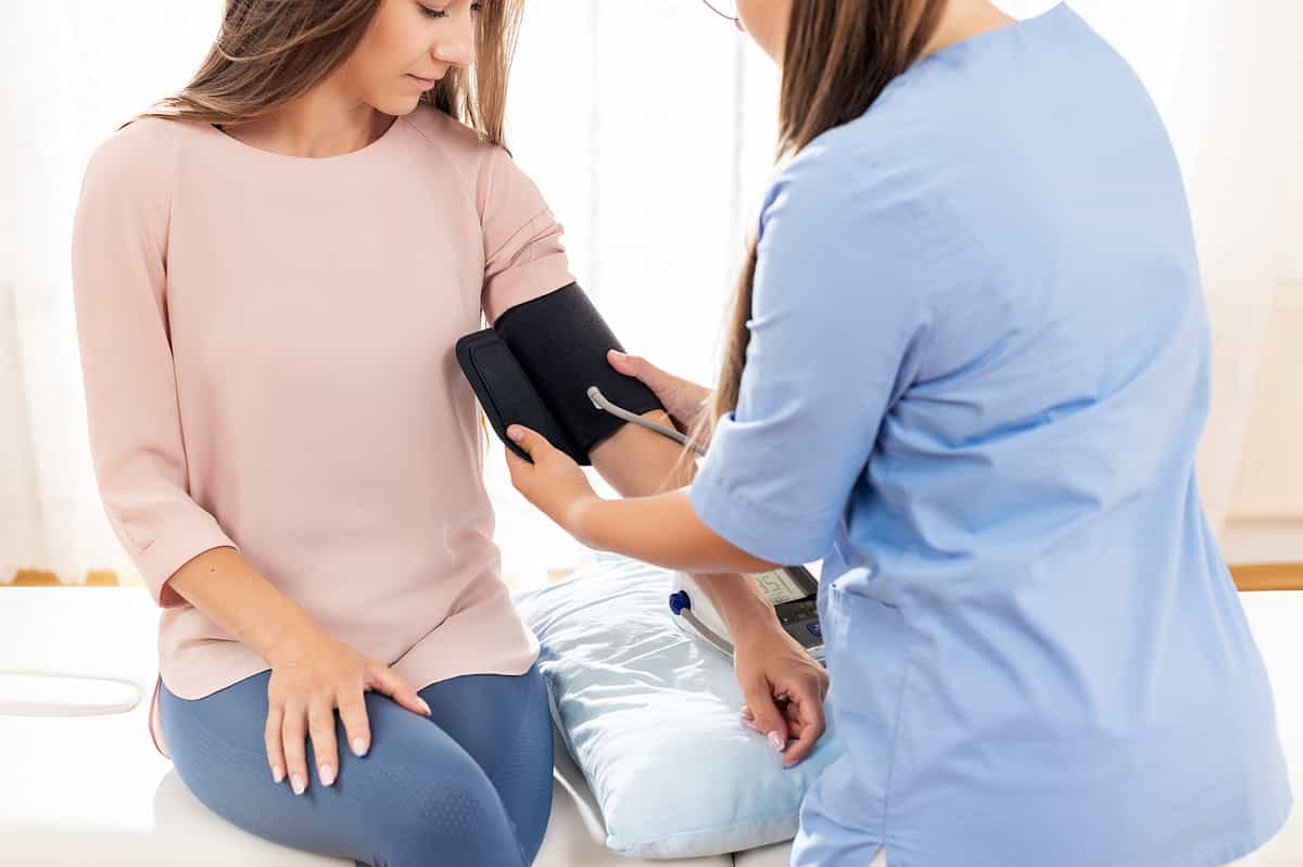 Young woman having her blood pressure taken by a nurse