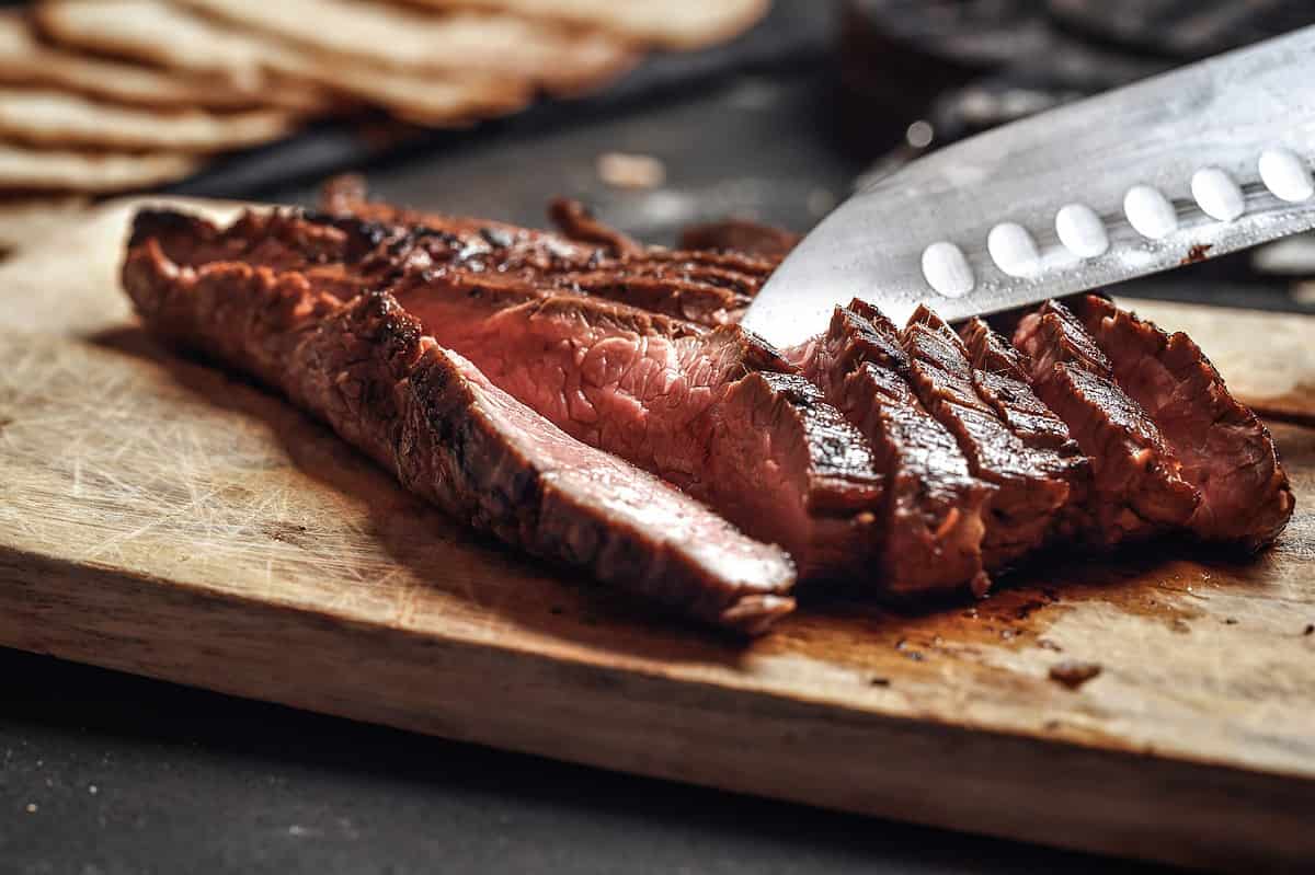 flank steak being cut into