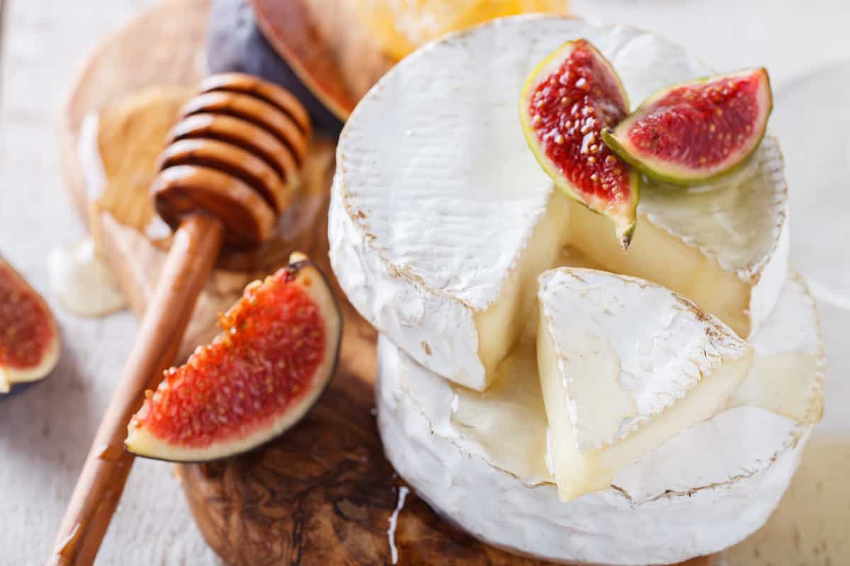 Brie,Cheese,On,A,Wooden,Board,With,Fresh,Figs,And