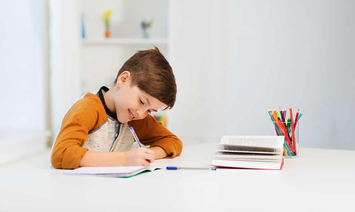 little boy writing and smiling