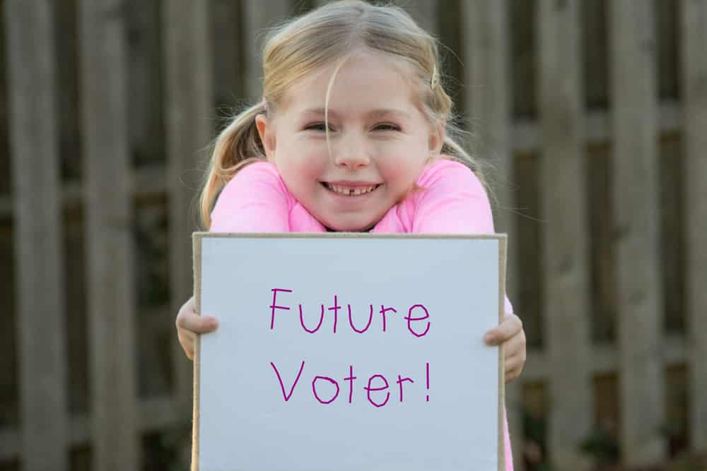 Young future voter holding banner