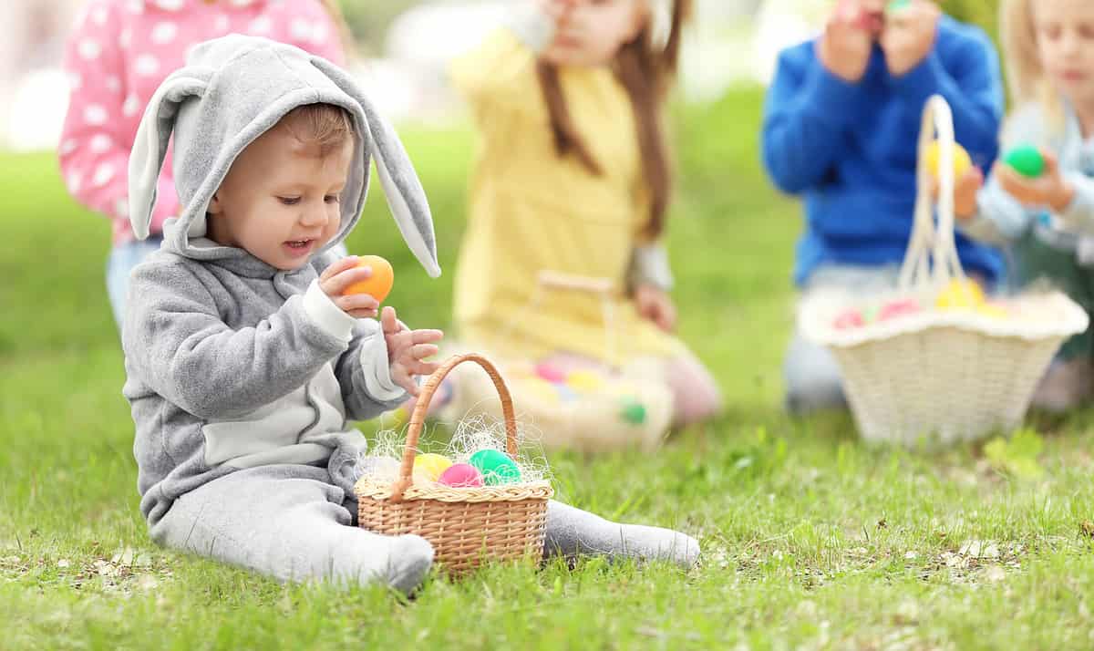 little boy holding an egg while on an Easter egg hunt
