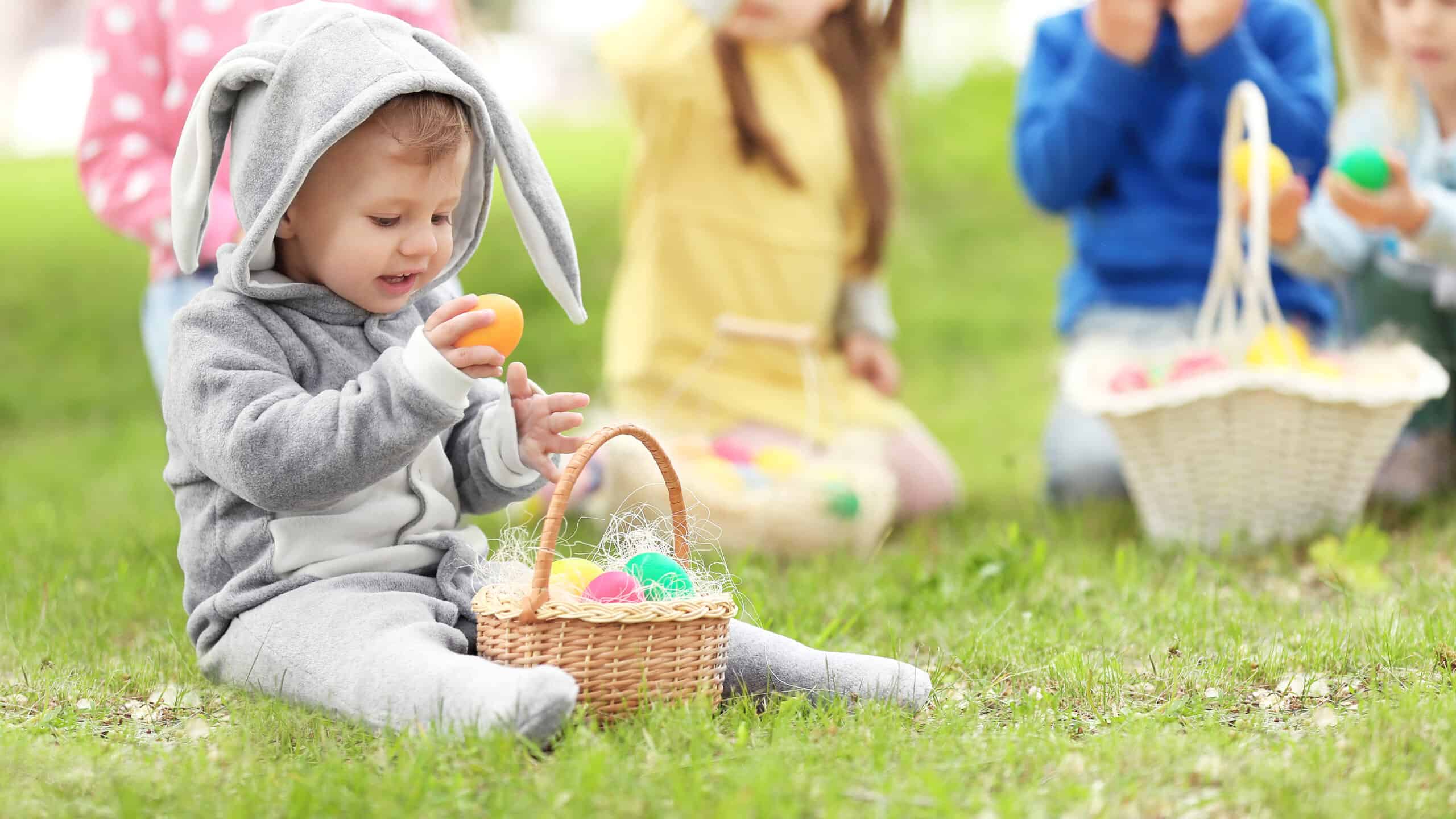 little boy holding an egg while on an Easter egg hunt