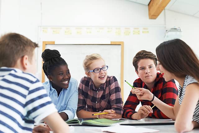 Group of Teenage Students Collaborating on Project in Classroom