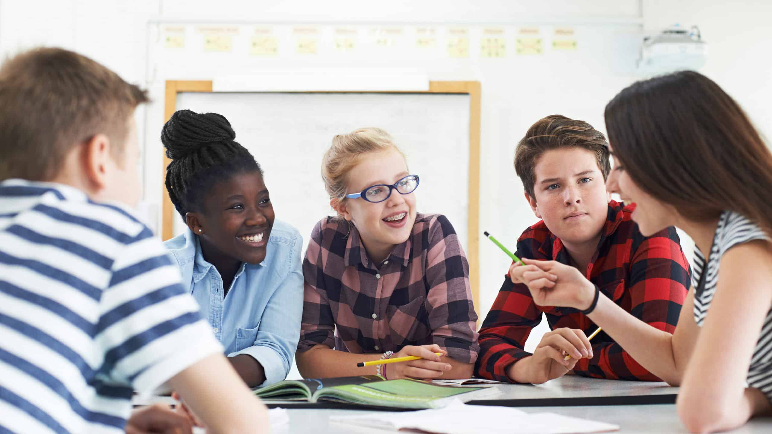 Group of Teenage Students Collaborating on Project in Classroom